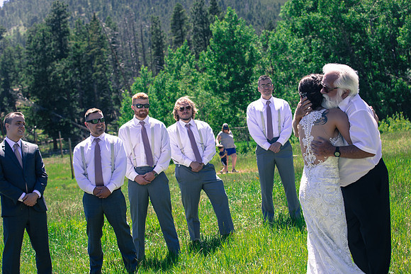 Groom looking at bride and father